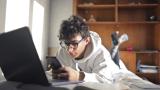 Student on phone while laptop is open